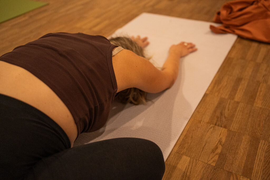 Entspannende Yoga-Endhaltung, Frau liegt ausgestreckt auf der Matte, Yoga Fotografie