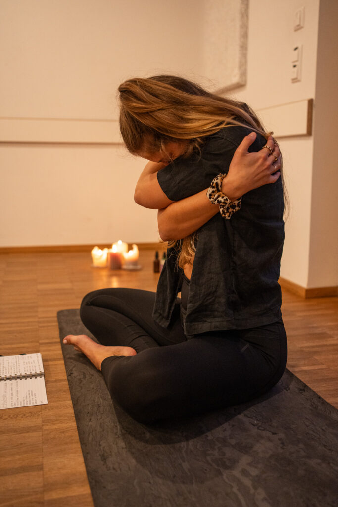 Frau umarmt sich selbst in entspannender Yoga-Praxis, Fotosession