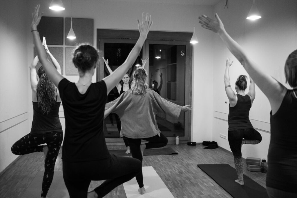 Schwarz-Weiß-Foto einer dynamischen Yoga-Gruppe in Balance, Fotoshooting Yoga