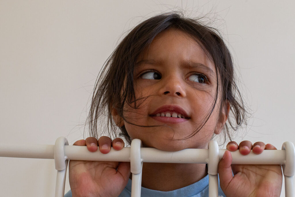 Porträt eines Mädchens hinter Gitterstäben des Betts