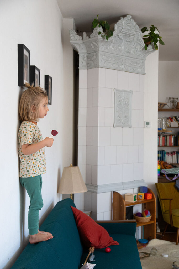 Kind steht auf Sofalehne mit Eis in der Hand, Dokumentarische Familienfotografie Esslingen, Familienreportage Esslingen