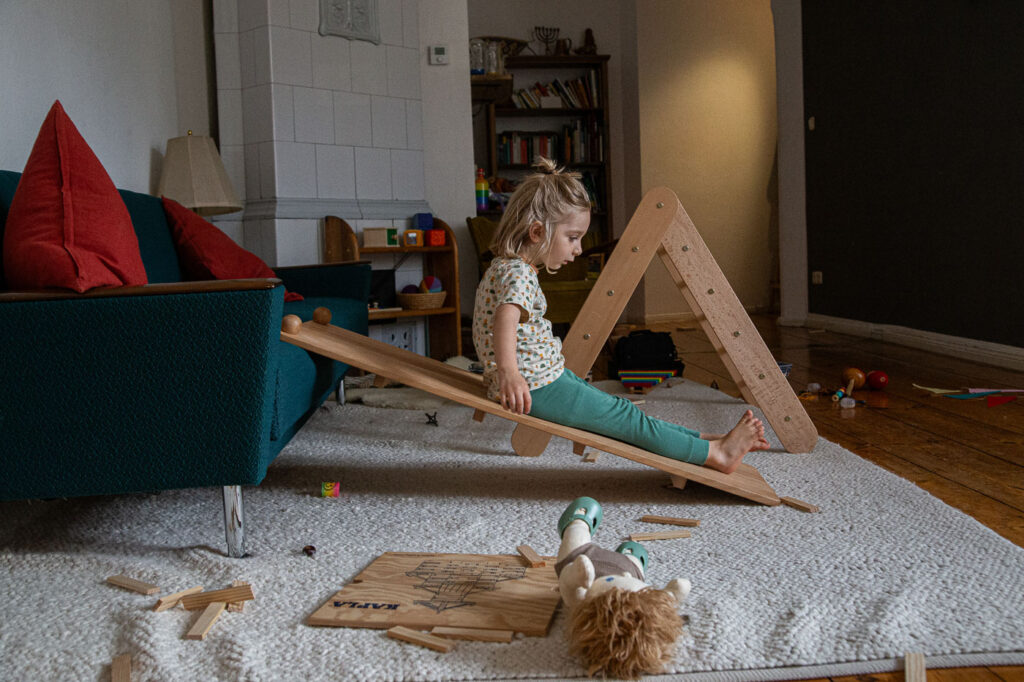 Kind rutscht im Wohnzimmer, Dokumentarische Familienfotografie Esslingen, Familienfotos Esslingen