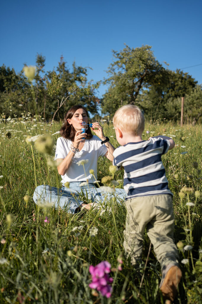 Mama mit Kind auf der Wiese, harmonisches Familienporträt mit Seifenblasen