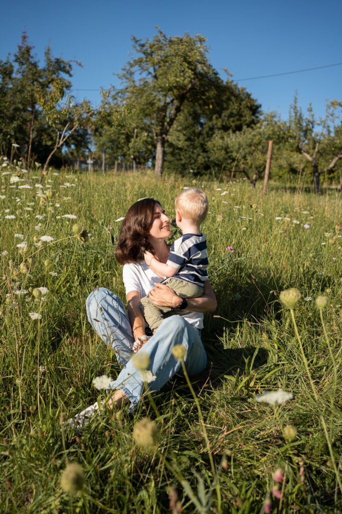 Inniger Moment: Mutter und Kind lachen gemeinsam im Gras