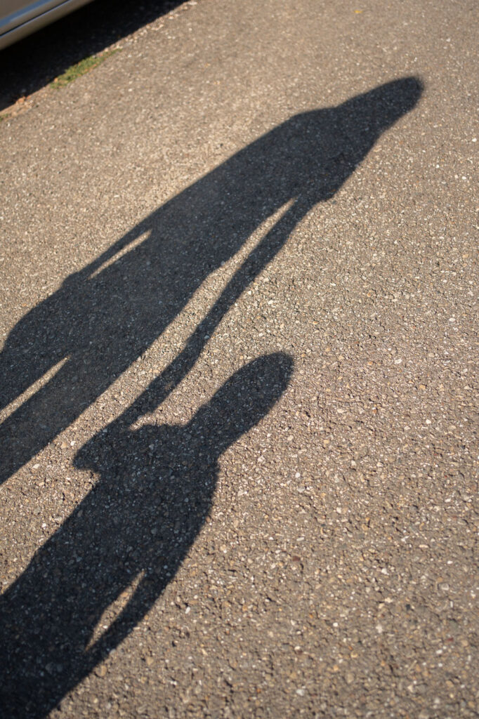 Schatten von Mutter und Kind beim Spaziergang, warme Abendsonne