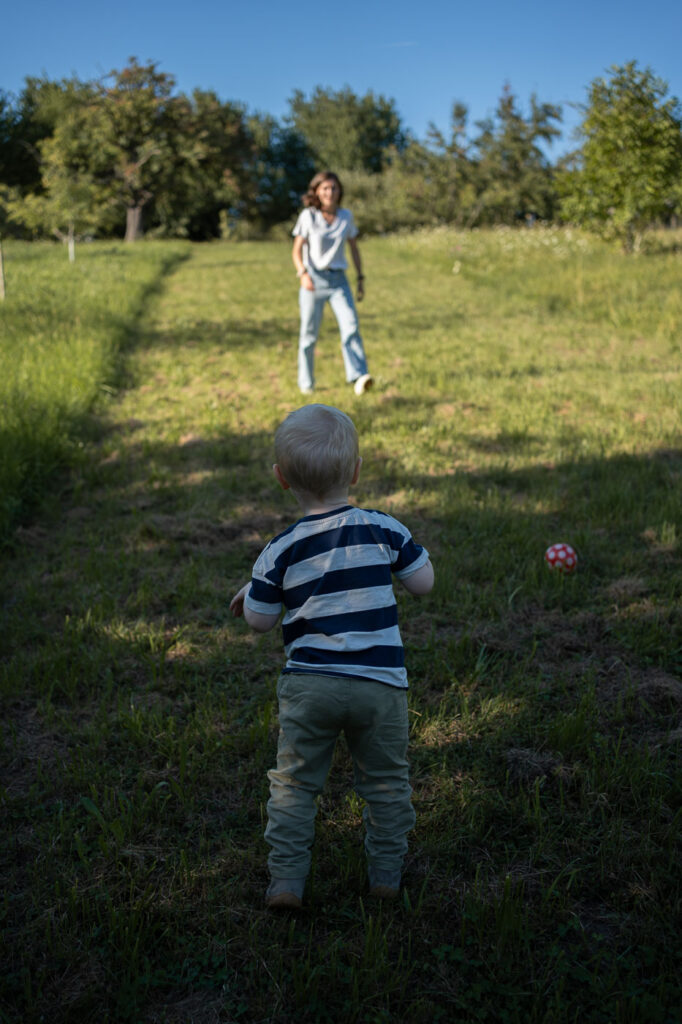 Kind läuft durch die Wiese, authentisches Outdoor-Familienfoto