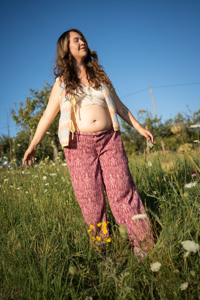 Porträtfoto einer Schwangeren im Sonnenuntergang, Selbstliebe mit Babybauch