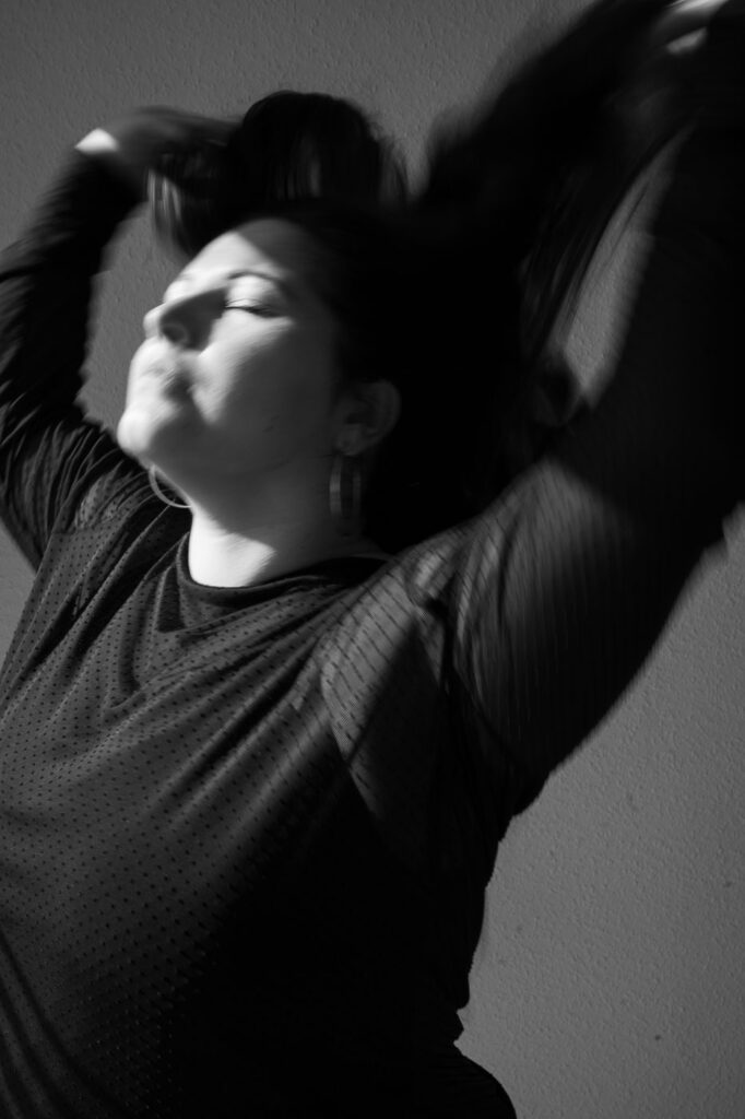 Künstlerisches Schwarzweißfoto: Frau lehnt sich zurück, starke Pose