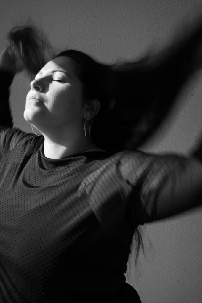 Schwarzweißporträt einer Frau, dynamische Bewegung mit offenen Haaren