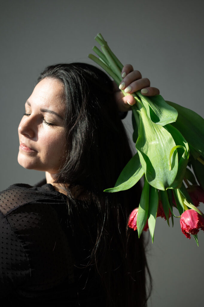 Selbstliebe-Fotoshooting: Frau mit Tulpenstrauß, sinnlicher Blick