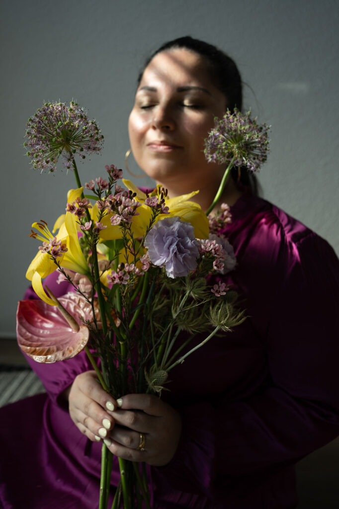 Authentisches Porträt: Frau mit buntem Blumenstrauß, positive Ausstrahlung