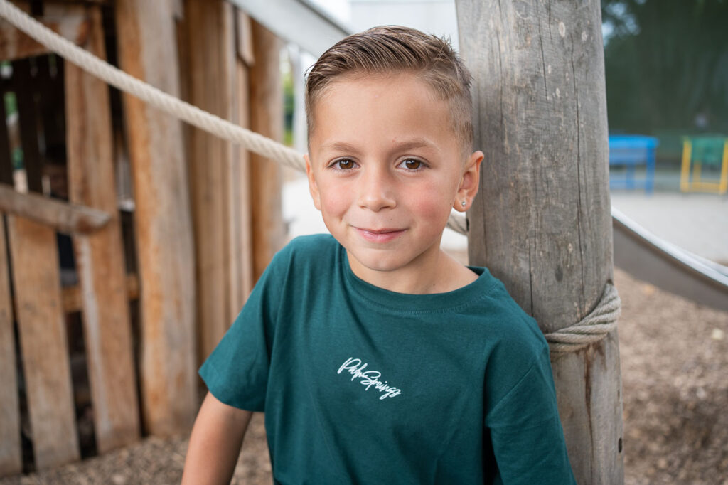 Junge lächelt auf Kitafoto, natürliche Kindergartenfotografie Esslingen