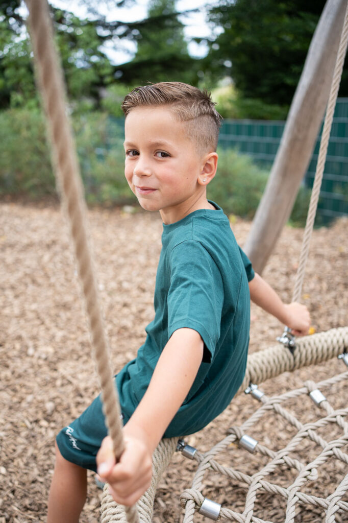 Junge schaut über Schulter bei Kitafoto, natürliche Kindergartenfotografie Esslingen, Stuttgart
