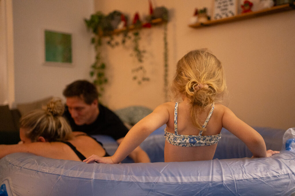 Frau und Kind im Geburtspool von hinten, Geburtsfotografie Esslingen